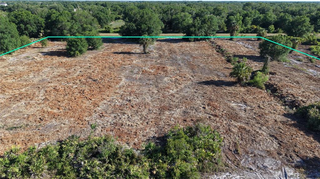 An aerial view shows a cleared, undeveloped plot of land surrounded by trees — 17017 NW 262ND STREET, OKEECHOBEE, FL