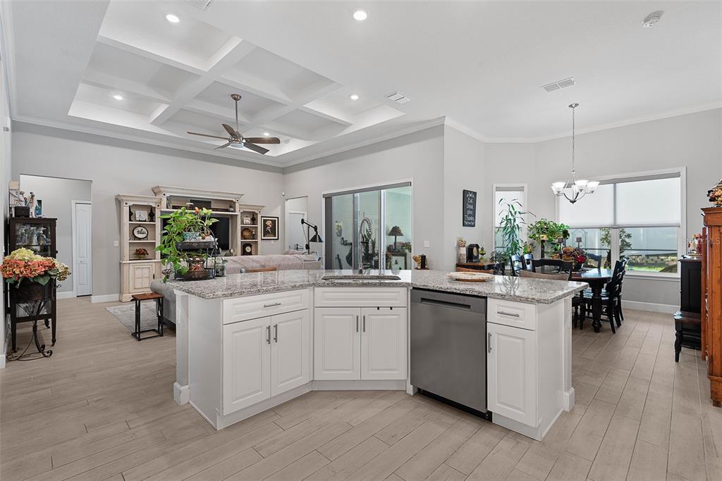 A kitchen island with granite countertops and white cabinets sits in an open-concept living space — 42 FRANCIS LANE, PALM COAST, FL