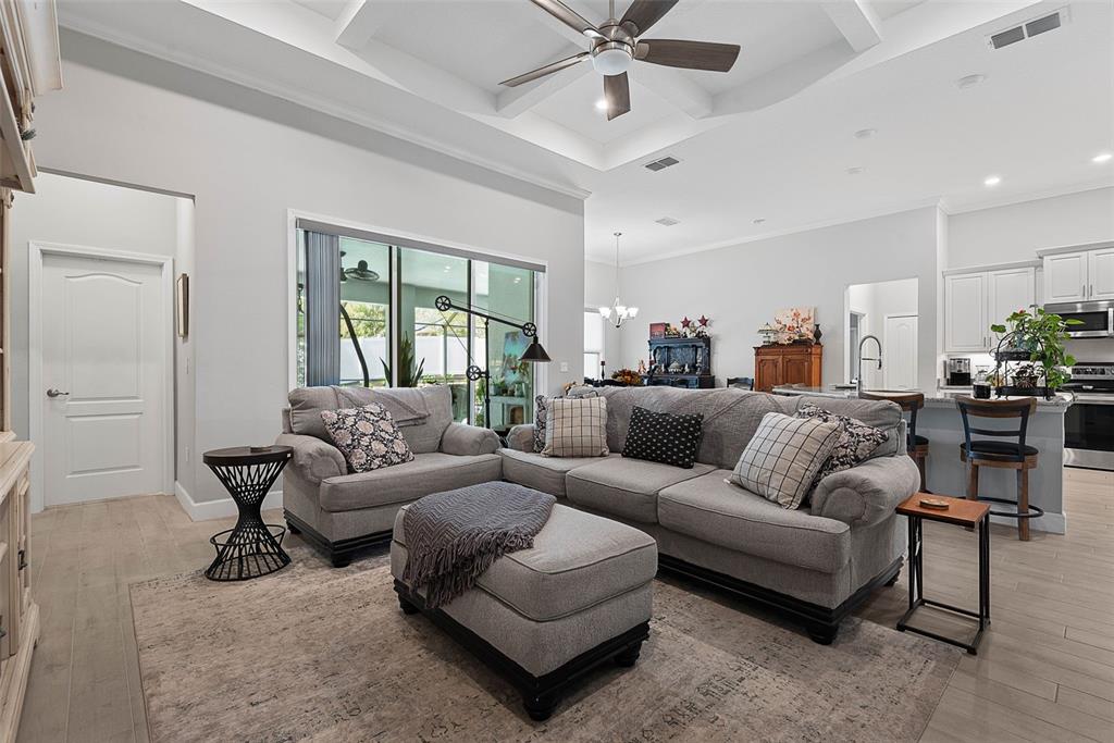 A living room features a grey sectional sofa, an ottoman, and a tray ceiling — 42 FRANCIS LANE, PALM COAST, FL