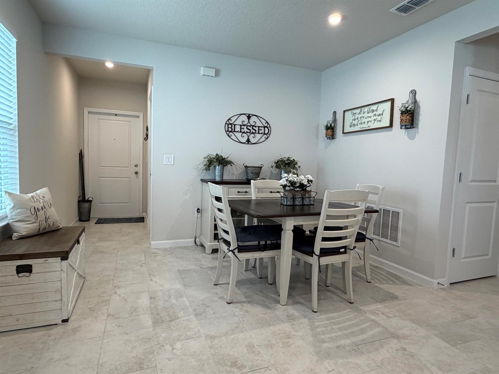 A dining area features a wooden table with white chairs, a sideboard, and tile flooring — 3030 Ruby Fls Drive, Deland FL 32724, DELAND, FL