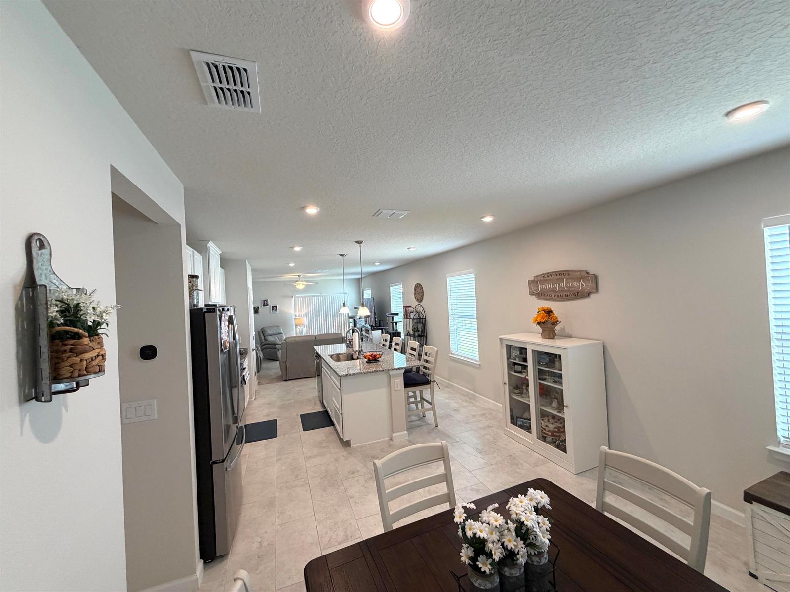 A kitchen with a granite island, stainless steel appliances, and a dining area — 3030 Ruby Fls Drive, Deland FL 32724, DELAND, FL