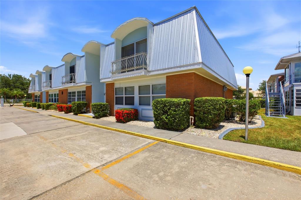 A two-story brick and metal-sided apartment building with balconies and a paved parking lot — 22333 EDGEWATER DRIVE UNIT C2, PUNTA GORDA, FL