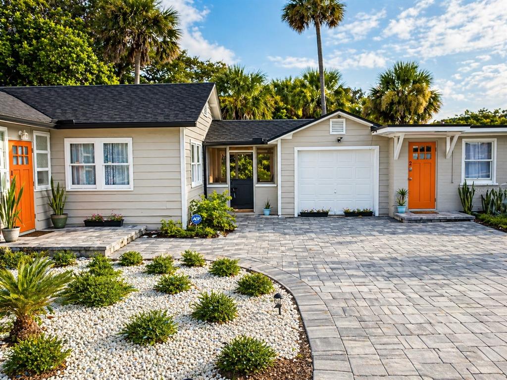 A single-story house with beige siding, two orange doors, and a paved driveway — 200 S PINE STREET, NEW SMYRNA BEACH, FL