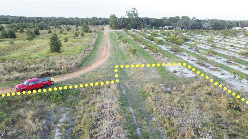 An aerial view shows a red pickup truck on a dirt road bordering a citrus grove — 1895 OTTO POLK ROAD, FROSTPROOF, FL
