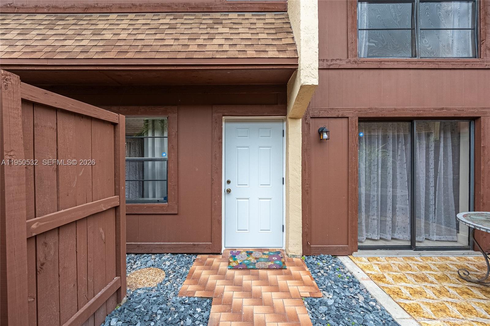 The exterior of a brown house features a white front door and a brick walkway — 6534 SW 114th Pl # 75, Miami FL 33173, MIAMI, FL