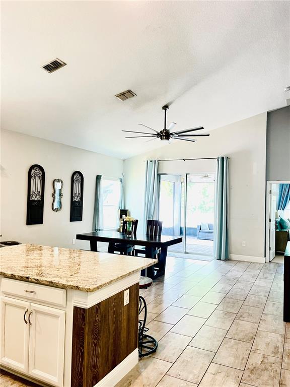 A living room features a sectional sofa, a wall-mounted television, and wood-look tile flooring — 3485 MIDDLEBROOK PLACE, HARMONY, FL