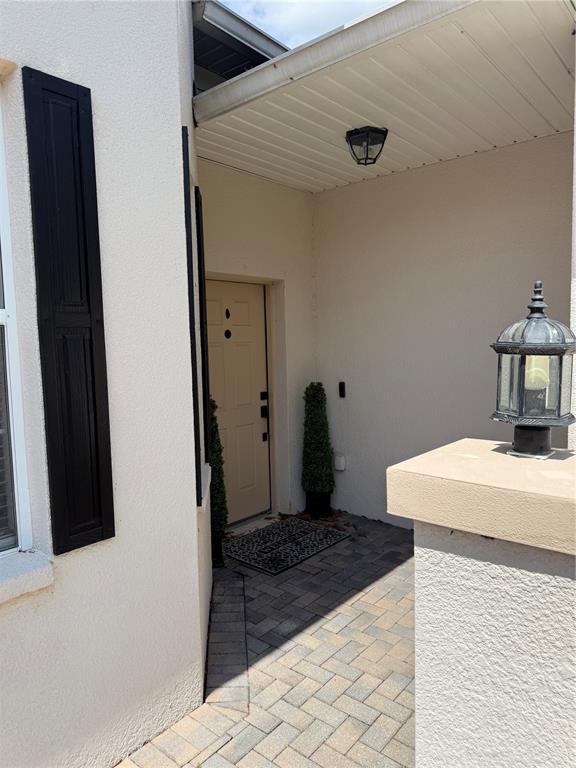 A paved walkway leads to a recessed front door with a lantern light fixture — 1018 GREEN GATE BOULEVARD, GROVELAND, FL