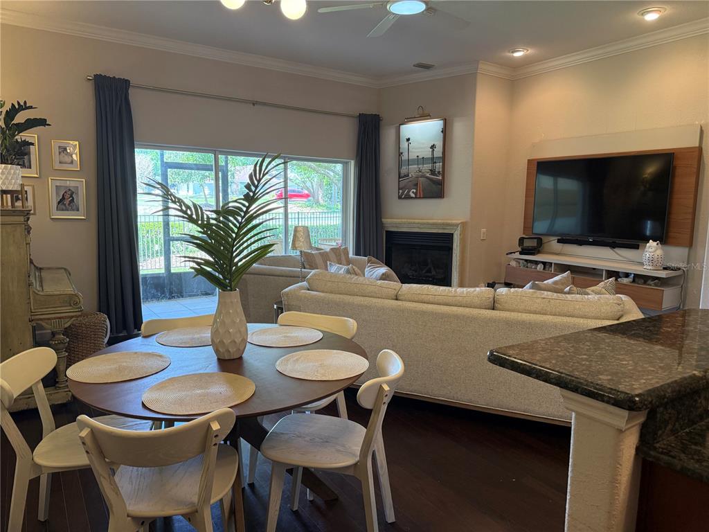 A kitchen features light-colored cabinets, dark granite countertops, stainless steel appliances, and two bar stools — 1018 GREEN GATE BOULEVARD, GROVELAND, FL