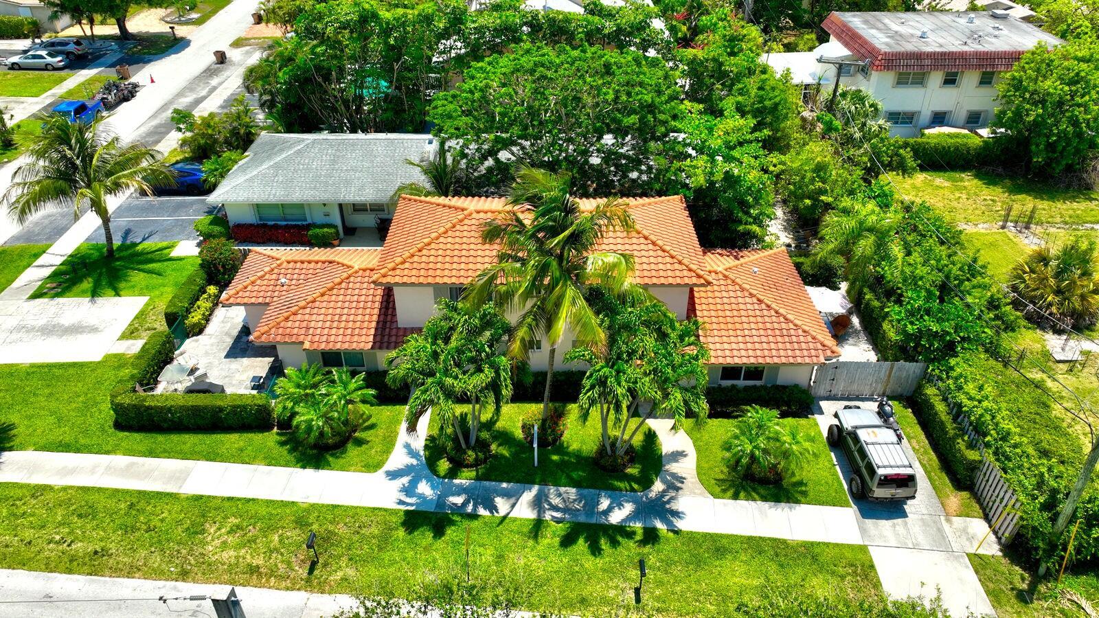 An aerial view of a single-story house with a terracotta tile roof and palm trees — 560-570 NE 19th Avenue, Deerfield Beach FL 33441, DEERFIELD BEACH, FL