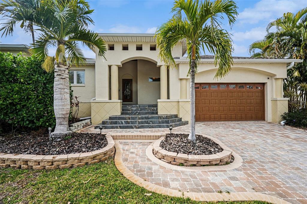 A single-story house with a paved driveway, palm trees, and a raised entryway with steps — 840 3RD AVENUE S, TIERRA VERDE, FL