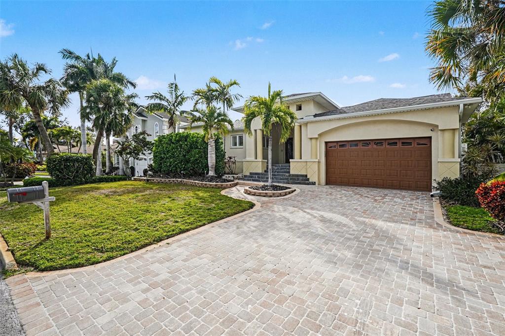 A single-story house with a paved driveway, palm trees, and a two-car garage — 840 3RD AVENUE S, TIERRA VERDE, FL