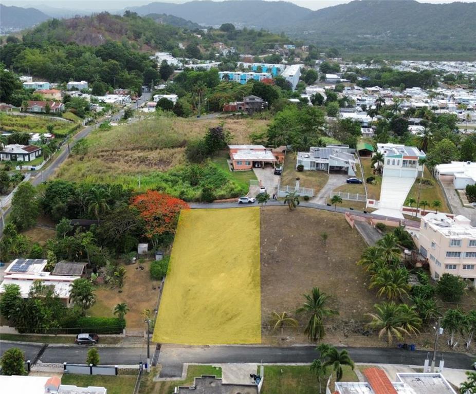 An aerial view shows a vacant rectangular lot highlighted in yellow within a residential neighborhood — 12 Miramelinda ST PARAISO SANTA BARBARA, GURABO, PR