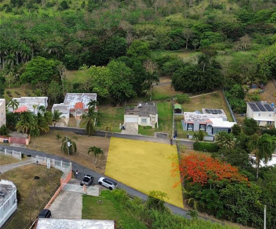 An aerial view shows a vacant, yellow-highlighted residential lot situated between houses and lush trees — 12 Miramelinda ST PARAISO SANTA BARBARA, GURABO, PR
