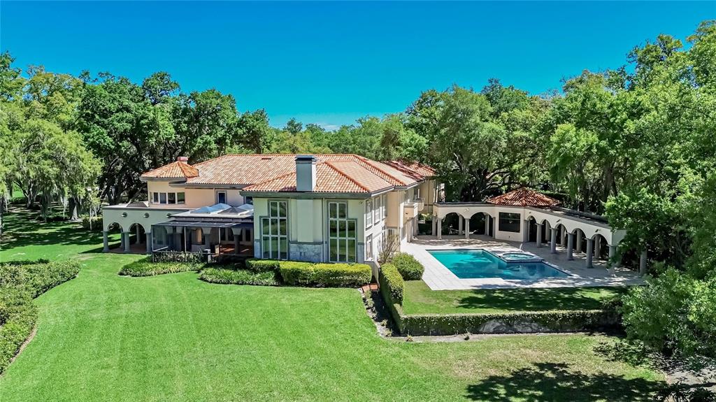 An aerial view of a large Mediterranean-style house with a tile roof, pool, and lawn — 1043 GUISANDO DE AVILA, TAMPA, FL