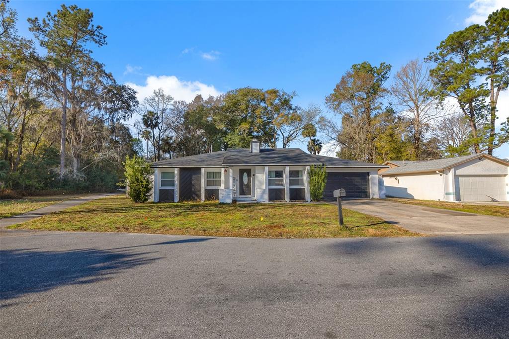 A single-story house with a dark garage, white trim, and a front yard — 872 FALKIRK DRIVE, WINTER SPRINGS, FL