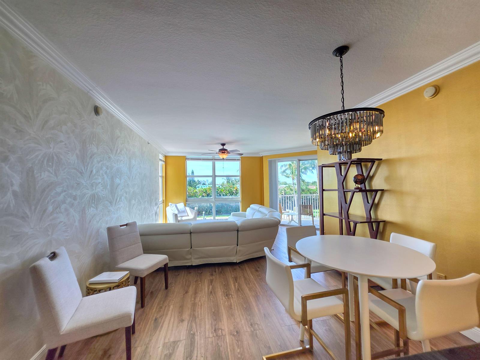 A living and dining room with yellow walls, a crystal chandelier, and white furniture — 806 E Windward Way # 323, Lantana FL 33462, LANTANA, FL