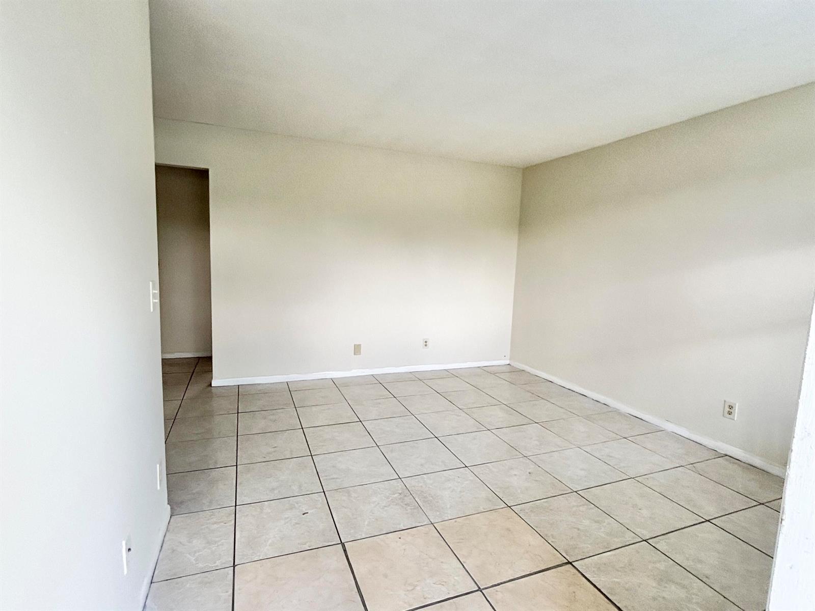 An empty room features light-colored tile flooring and plain, off-white walls — 1111 N Federal Highway # 5, FL 33460, FL