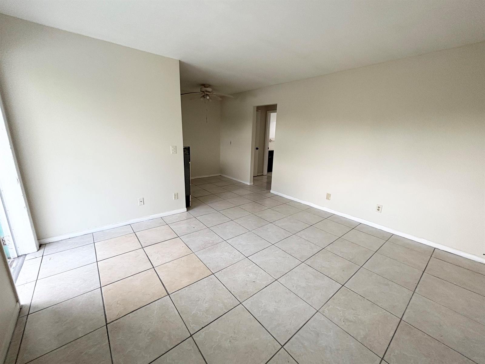 An empty room with light-colored tile flooring, beige walls, and a ceiling fan — 1111 N Federal Highway # 5, FL 33460, FL