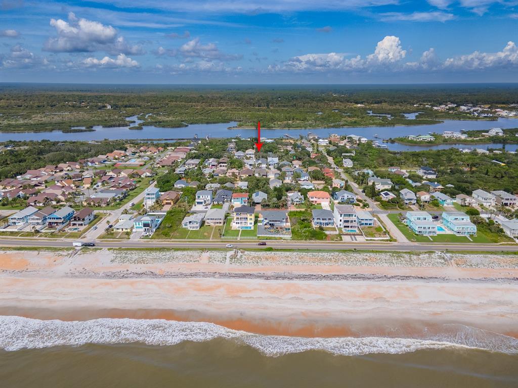 An aerial view shows a coastal neighborhood with houses situated between a beach and a waterway — 2721 S JOHN BULL STREET, FLAGLER BEACH, FL