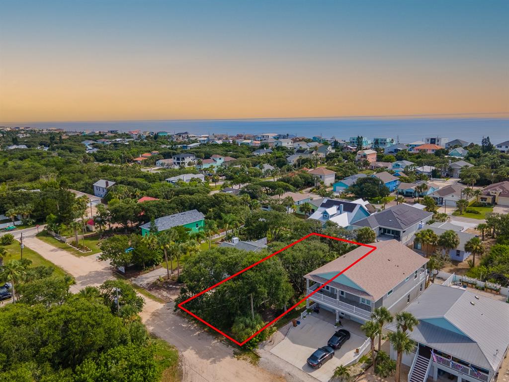 An aerial view shows a vacant, tree-covered lot outlined in red next to a two-story house — 2721 S JOHN BULL STREET, FLAGLER BEACH, FL