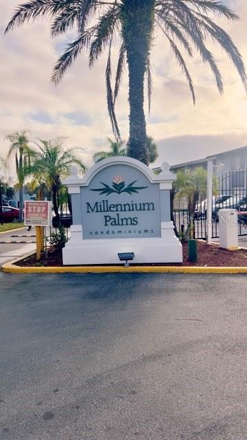 A sign for Millennium Palms stands near a road with palm trees and apartment buildings — 4743 S TEXAS AVENUE UNIT 4743B, ORLANDO, FL