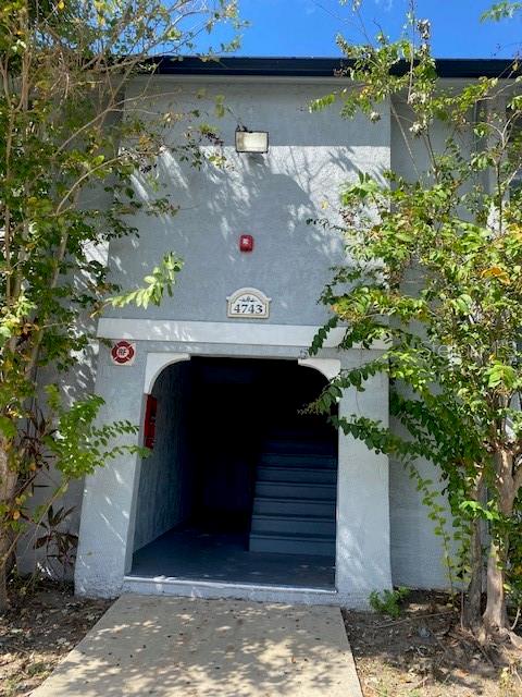 An exterior view of a building entrance with a concrete staircase leading inside — 4743 S TEXAS AVENUE UNIT 4743B, ORLANDO, FL
