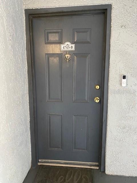 A gray front door with a brass knocker and a doorbell camera on the wall — 4743 S TEXAS AVENUE UNIT 4743B, ORLANDO, FL