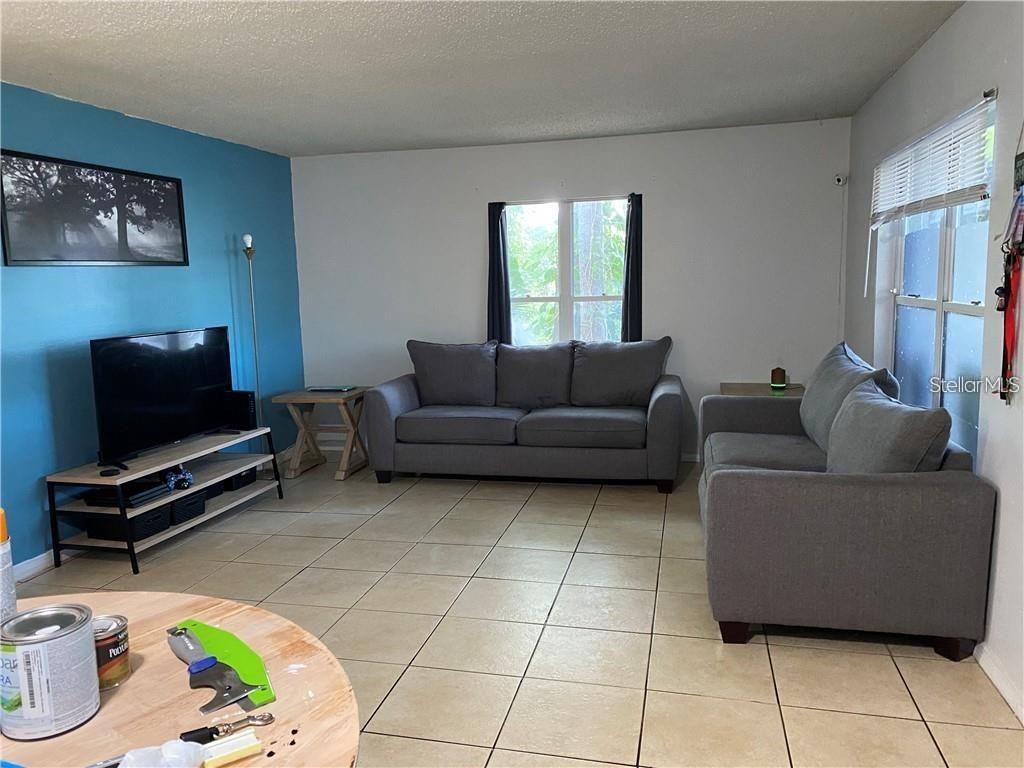 A living room features a blue accent wall, gray sofas, and light-colored tile flooring — 2404 NORTHLAKE DRIVE NE UNIT 2404, SANFORD, FL
