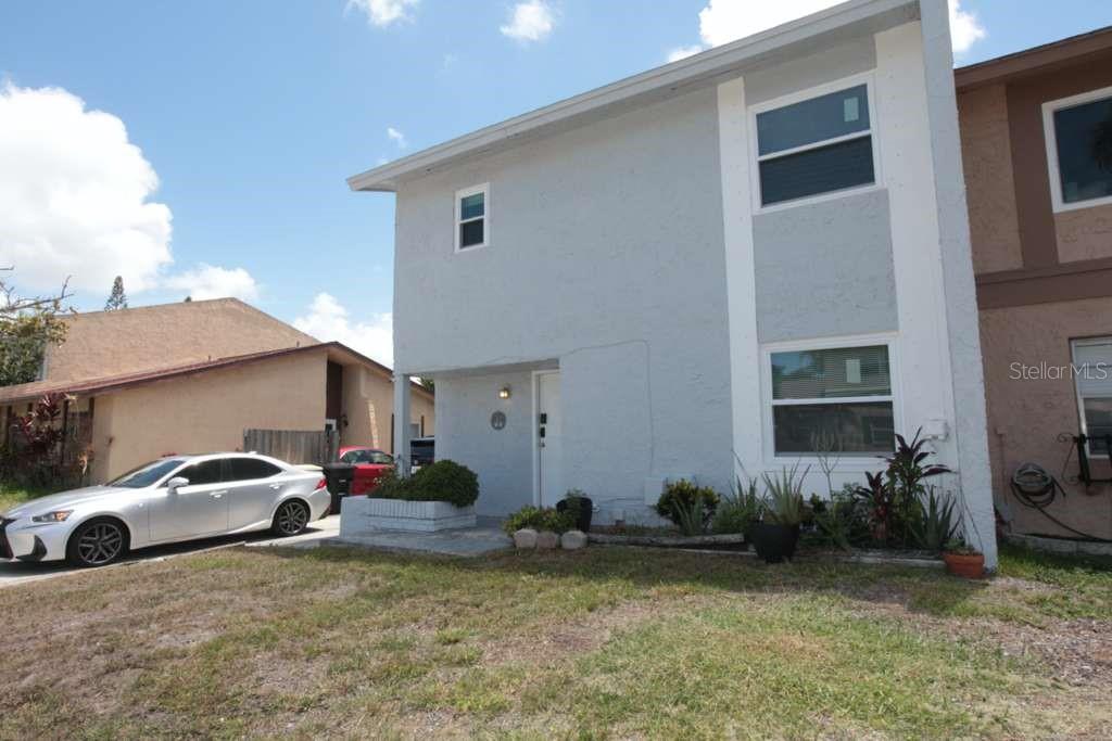 A two-story light blue house with a white front door and a parked silver car — 2073 SAN SEBASTIAN WAY N, CLEARWATER, FL
