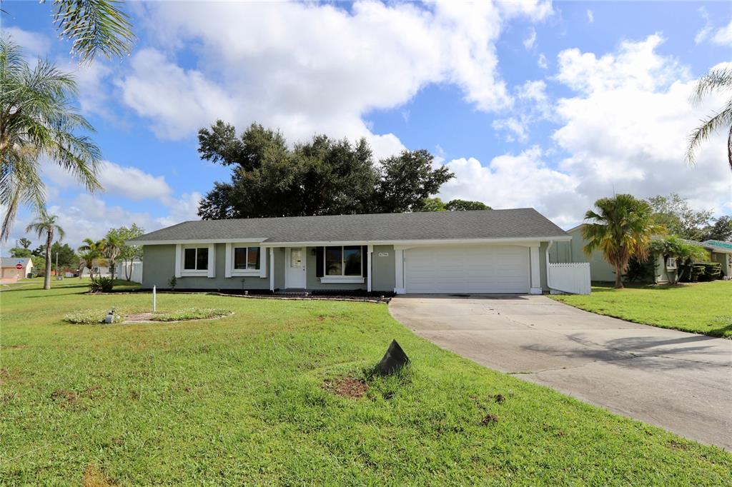 A single-story house with a light green exterior, a white garage door, and a grassy lawn — 6796 ELECTRA AVENUE, NORTH PORT, FL