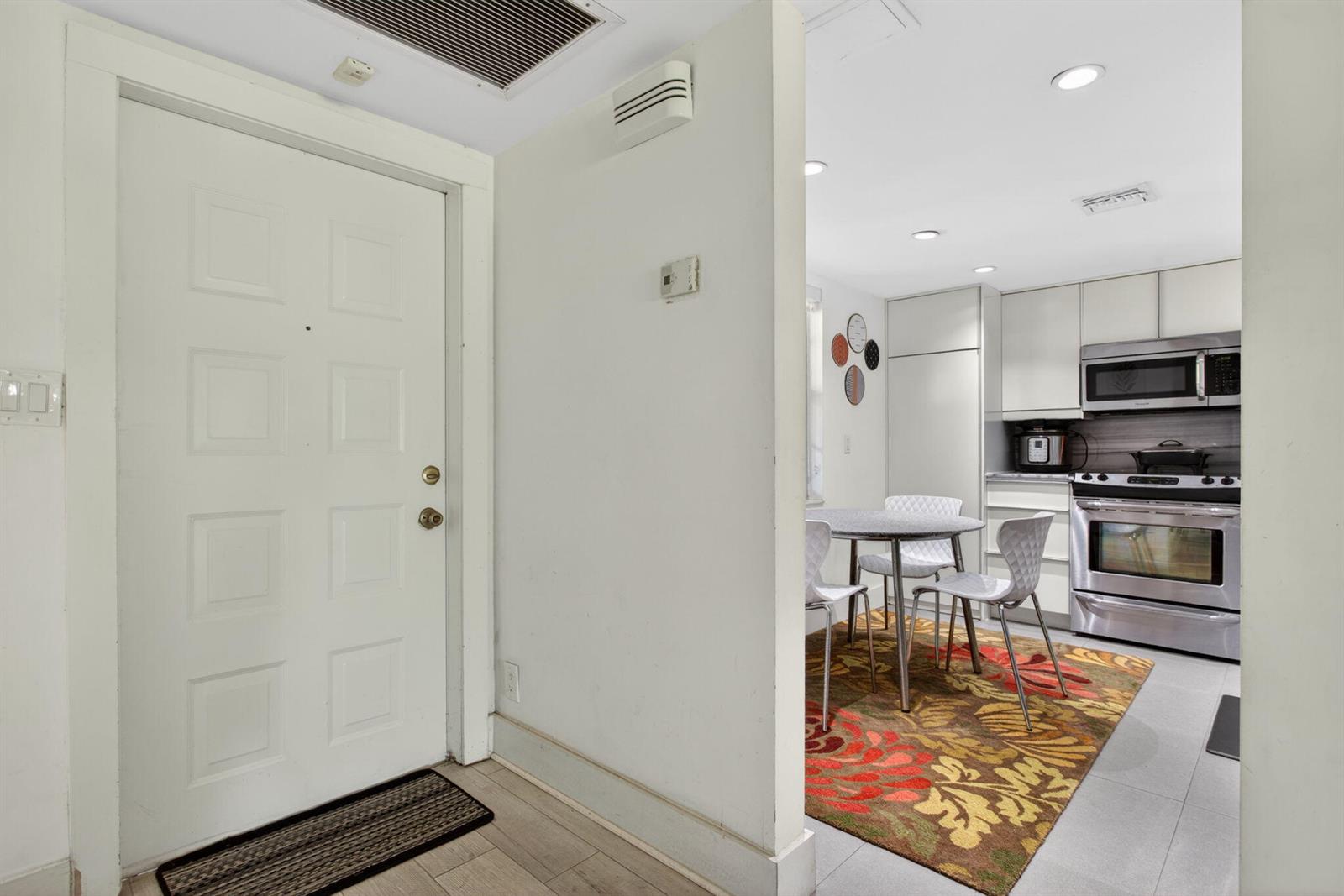 A white front door opens into a kitchen area with a small dining table — 901 W Cypress Lane # 103, Pompano Beach FL 33069, POMPANO BEACH, FL