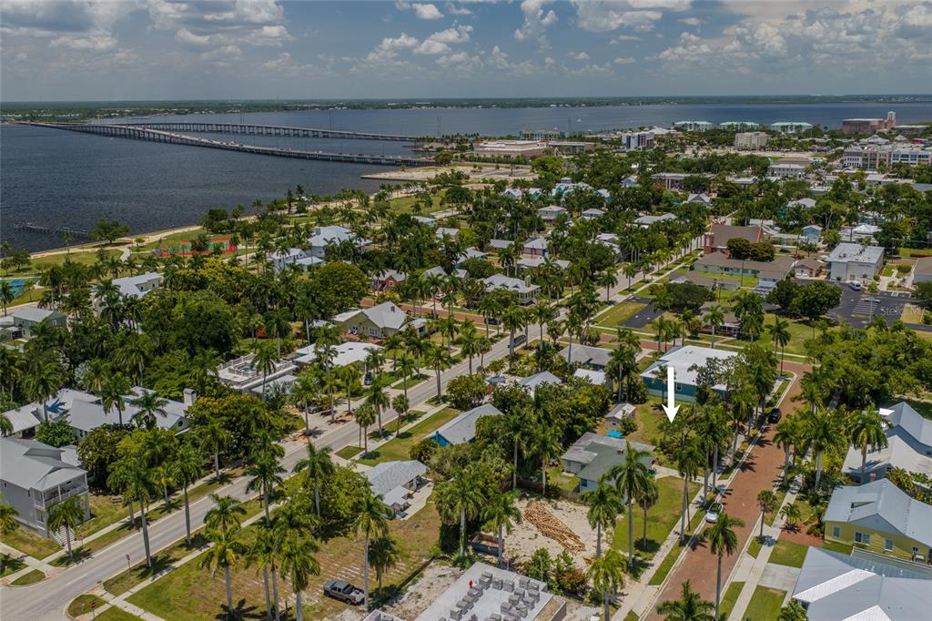 An aerial view of a coastal neighborhood with a white arrow pointing to a house — 610 TRABUE AVENUE, PUNTA GORDA, FL