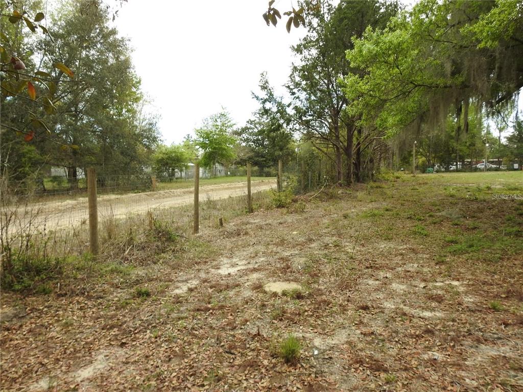 A dirt path runs alongside a wire fence on a wooded, undeveloped lot — 103 GEORGE DRIVE, INTERLACHEN, FL
