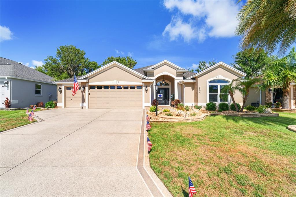A single-story house with a beige stucco exterior, a three-car garage, and a concrete driveway — 3806 VIEW PATH, THE VILLAGES, FL