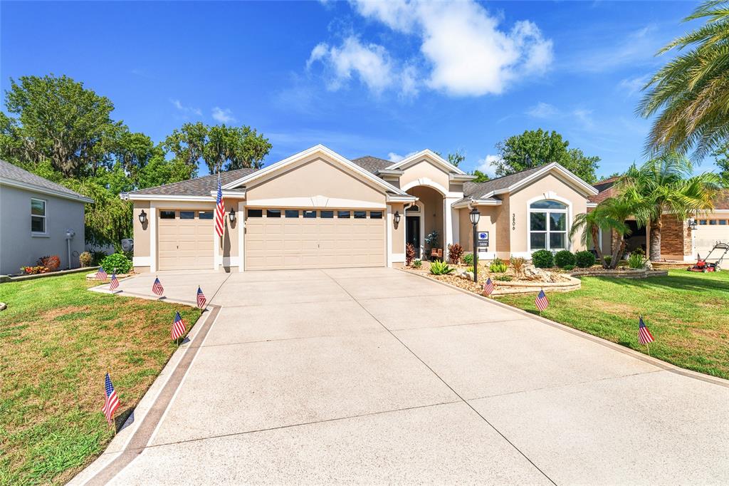 A single-story suburban house with a beige stucco exterior and a three-car garage — 3806 VIEW PATH, THE VILLAGES, FL