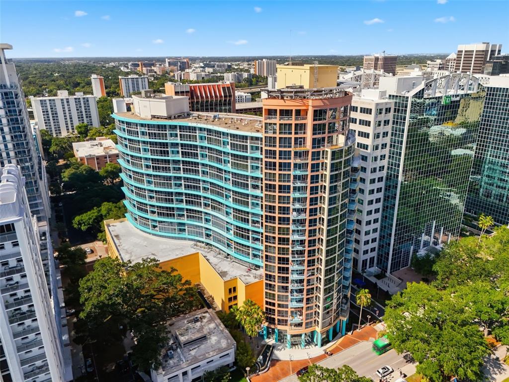 An aerial view of a curved, multi-story residential building with blue glass balconies and windows — 322 E CENTRAL BOULEVARD UNIT 912, ORLANDO, FL