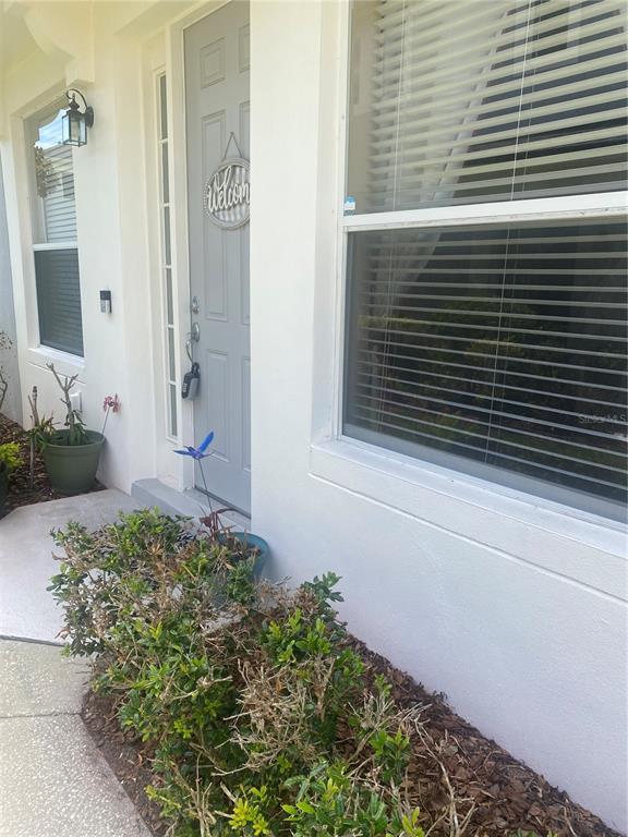 A view of a home exterior featuring a gray front door and a large window — 1532 SHALLCROSS AVE, ORLANDO, FL