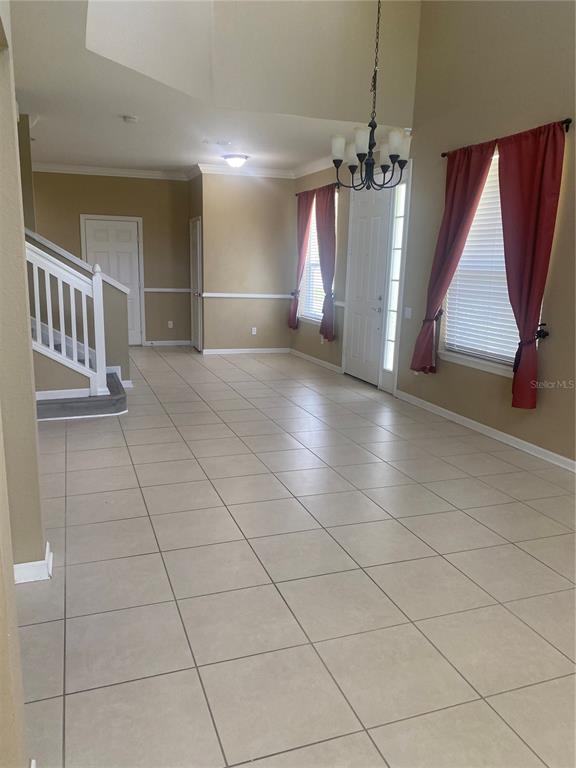 An entryway with tile flooring, a staircase, and a chandelier in a room with windows — 1532 SHALLCROSS AVE, ORLANDO, FL