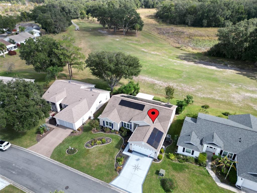 An aerial view of a suburban house with solar panels on the roof — 4704 RIVER RIDGE DRIVE, LEESBURG, FL