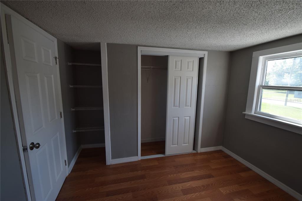 A bedroom with gray walls, wood-look flooring, a window, and two closet spaces — 1060 E WABASH STREET UNIT 1060 1/2, BARTOW, FL