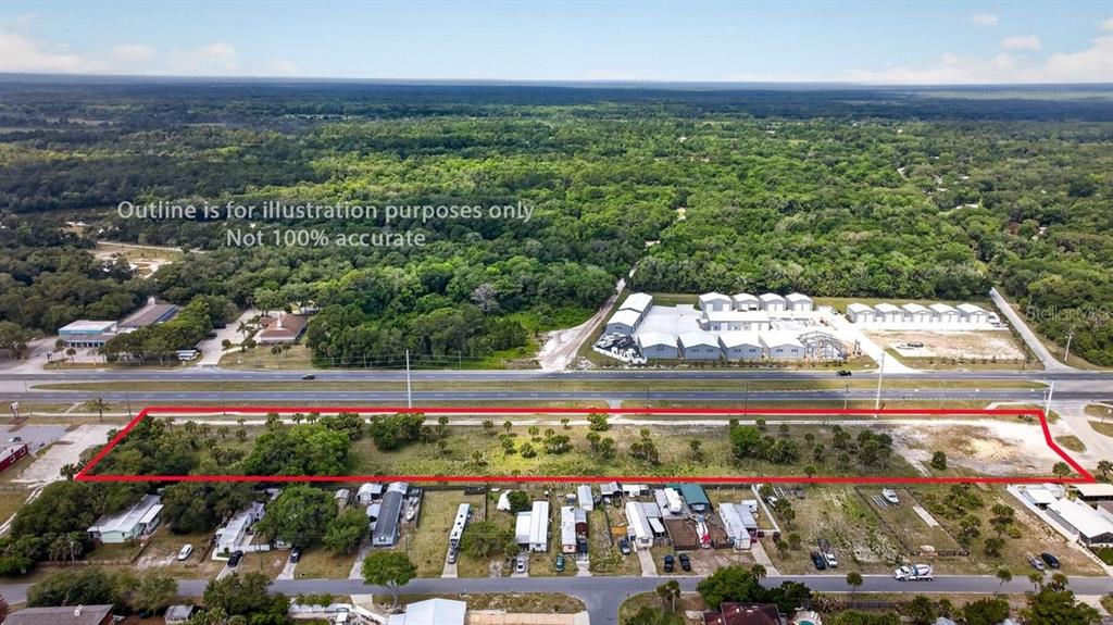 An aerial view shows a rectangular vacant lot outlined in red next to a highway — N US HWY 1, OAK HILL, FL