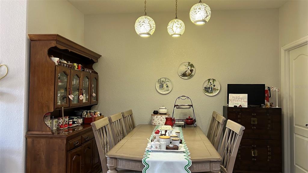 A dining room features a wooden hutch, a table with chairs, and three decorative wall plates — 17334 PROMENADE DRIVE, CLERMONT, FL