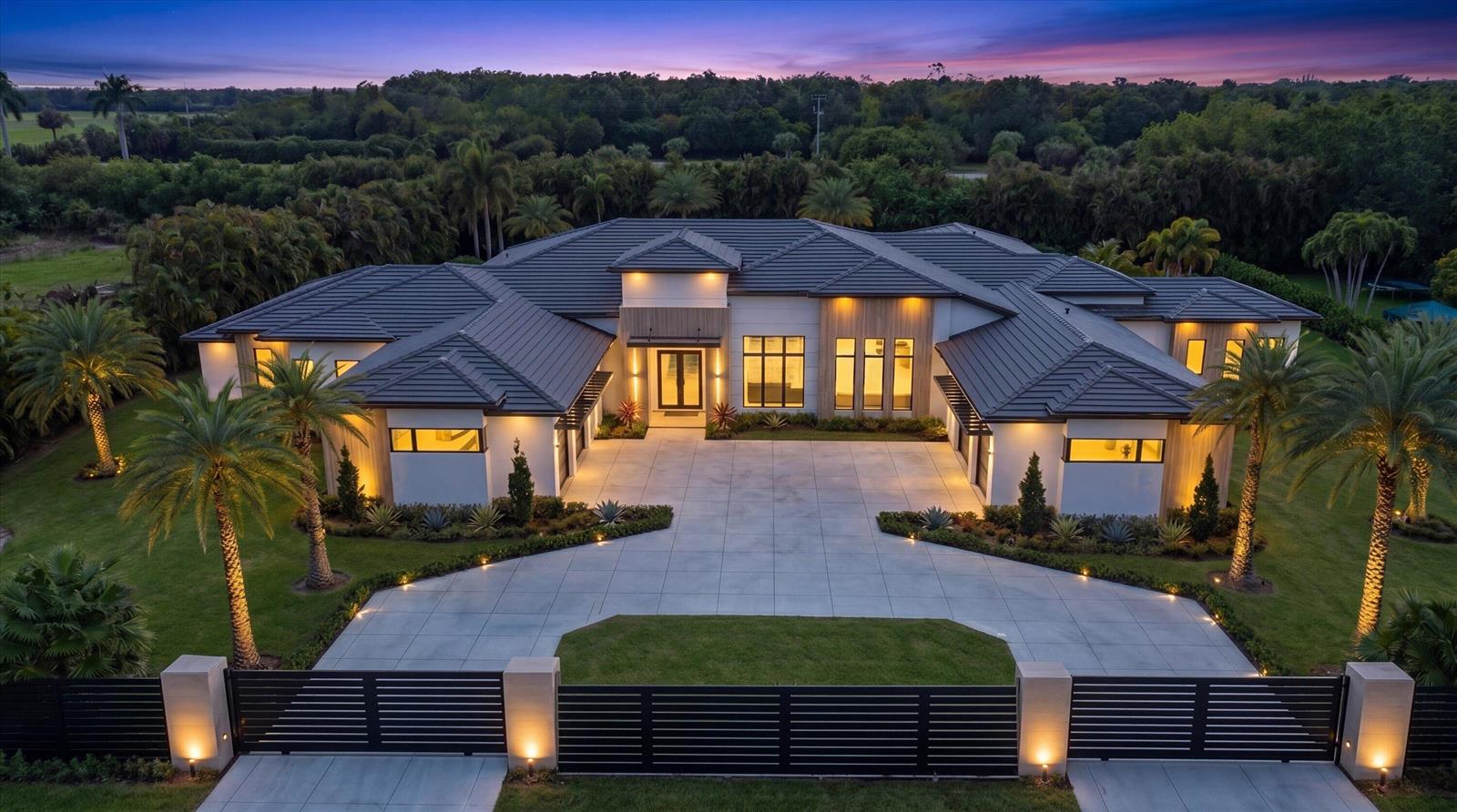 An aerial view of a modern single-story house with a tiled roof and gated driveway — 3905 Fieldview Way, Wellington FL 33414, WELLINGTON, FL