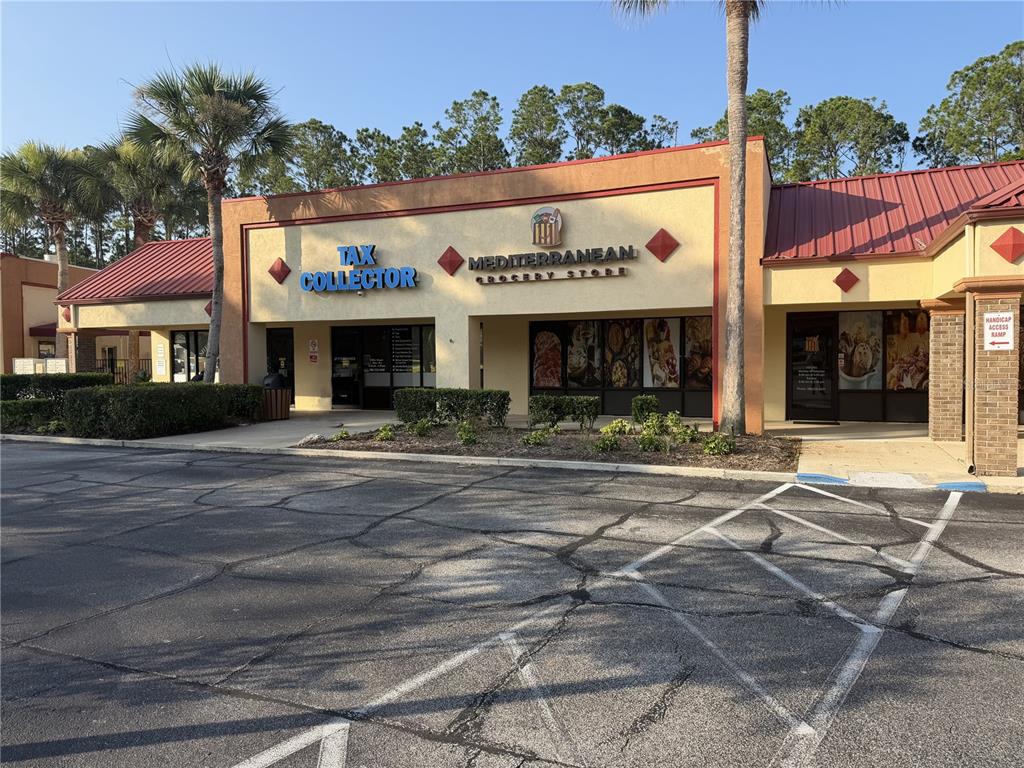 A commercial strip mall building features a tax collector office and a Mediterranean grocery store — 212 ST JOE PLAZA DRIVE, PALM COAST, FL