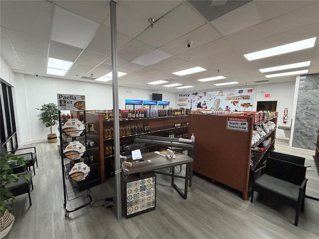 A retail space features shelving units, a checkout desk, and a wall mural of Italy — 212 ST JOE PLAZA DRIVE, PALM COAST, FL