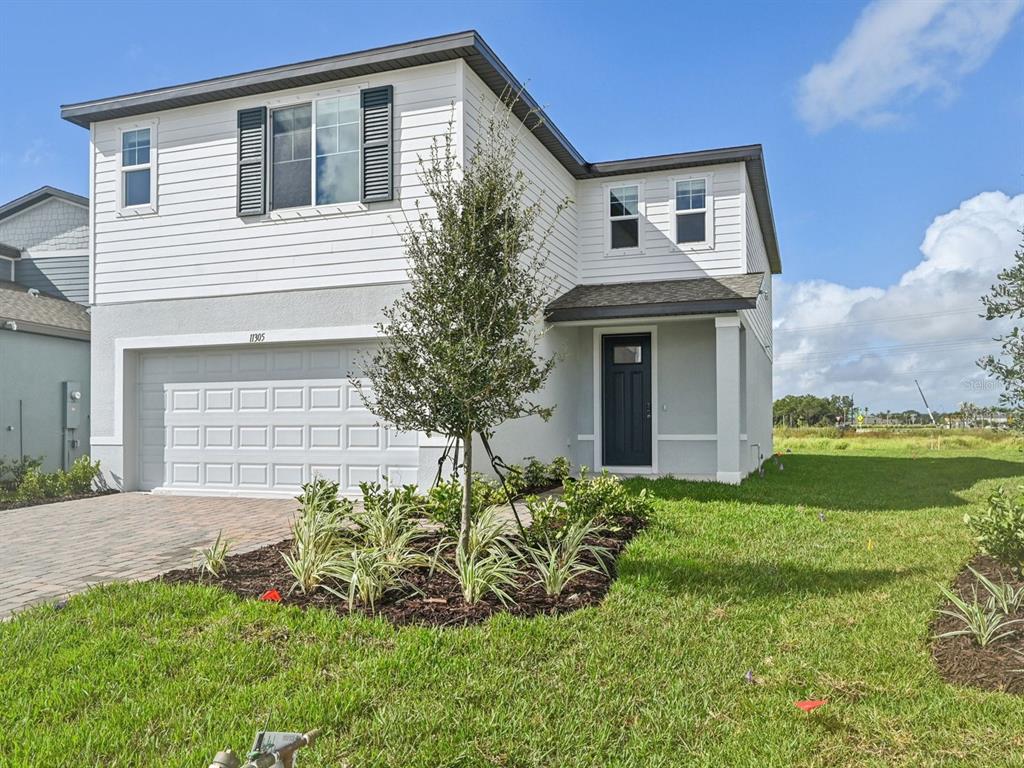 A two-story house with white siding, a two-car garage, and a small front yard — 11305 BELLEWOOD TERRACE, PARRISH, FL