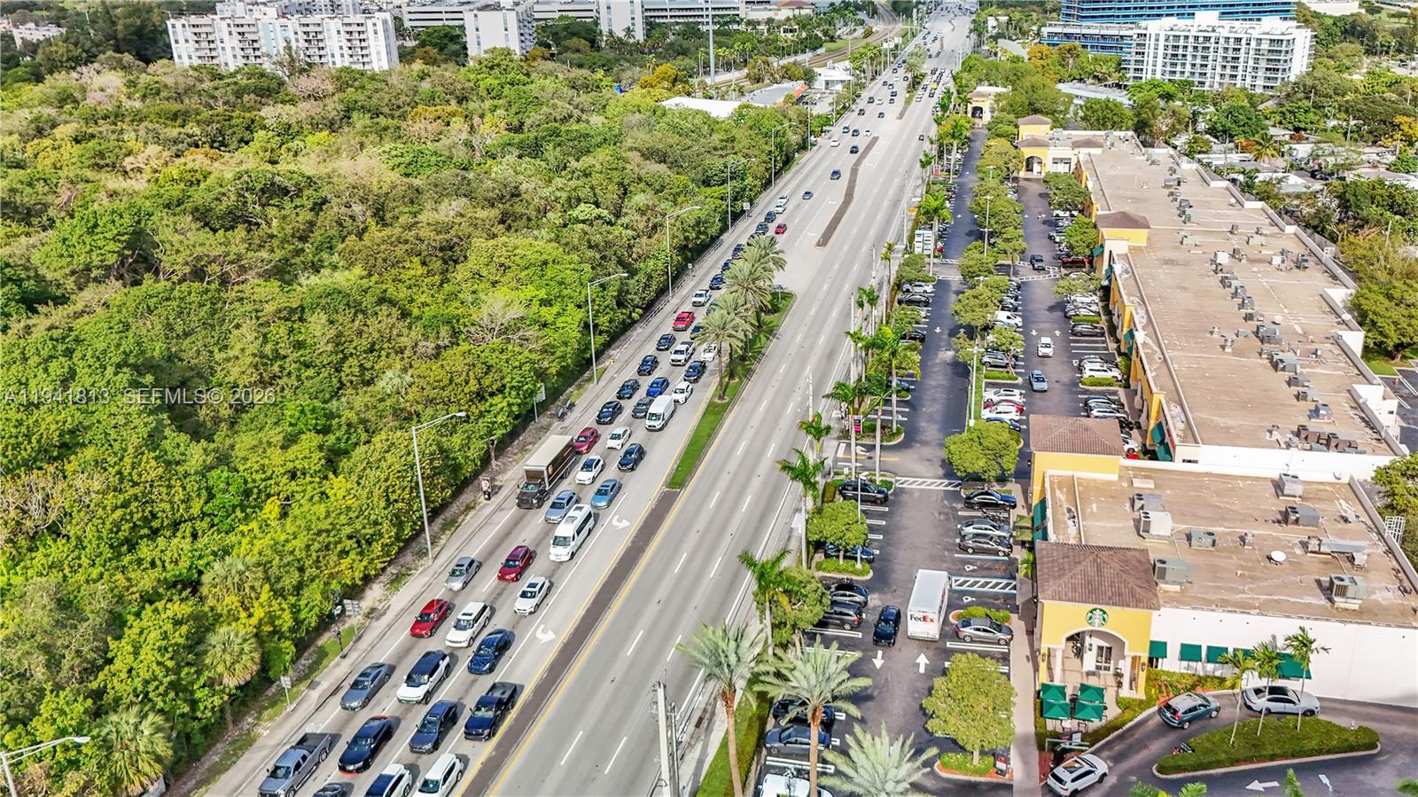 An aerial view shows a multi-lane road with heavy traffic beside a commercial shopping center — 13499 Biscayne Blvd # 3, North Miami FL 33181, NORTH MIAMI, FL