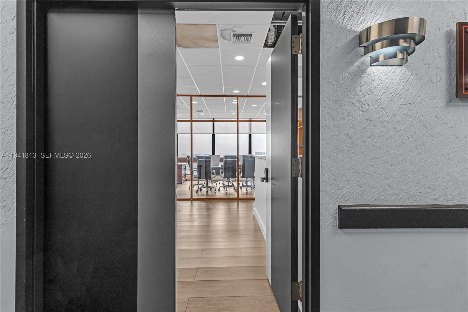 A doorway opens into an office space with wood flooring and glass-walled conference rooms — 13499 Biscayne Blvd # 3, North Miami FL 33181, NORTH MIAMI, FL
