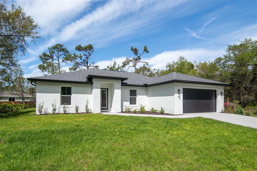 A single-story white house with a dark roof and a two-car garage — 49 TROUTDALE STREET, PORT CHARLOTTE, FL