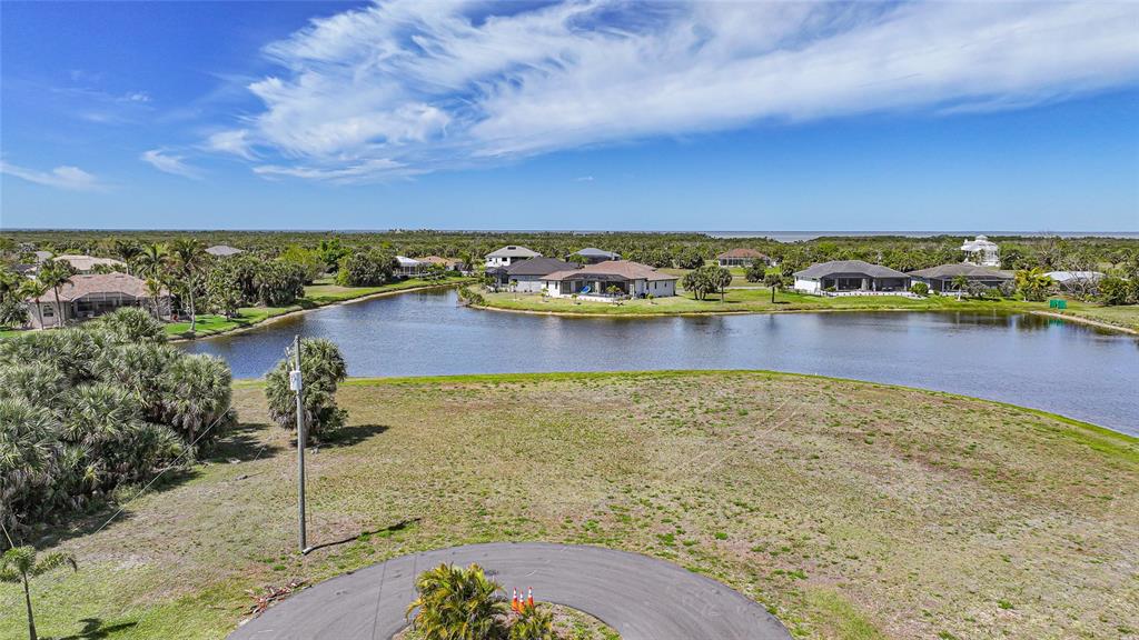 An aerial view shows a vacant waterfront lot with a cul-de-sac in the foreground — 16395 NOGALES COURT, PUNTA GORDA, FL